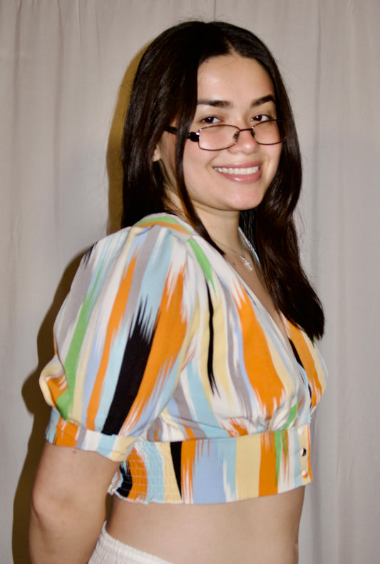 Abstract print crop top blouse with streaks of orange, gray, blue, white, green, and yellow.