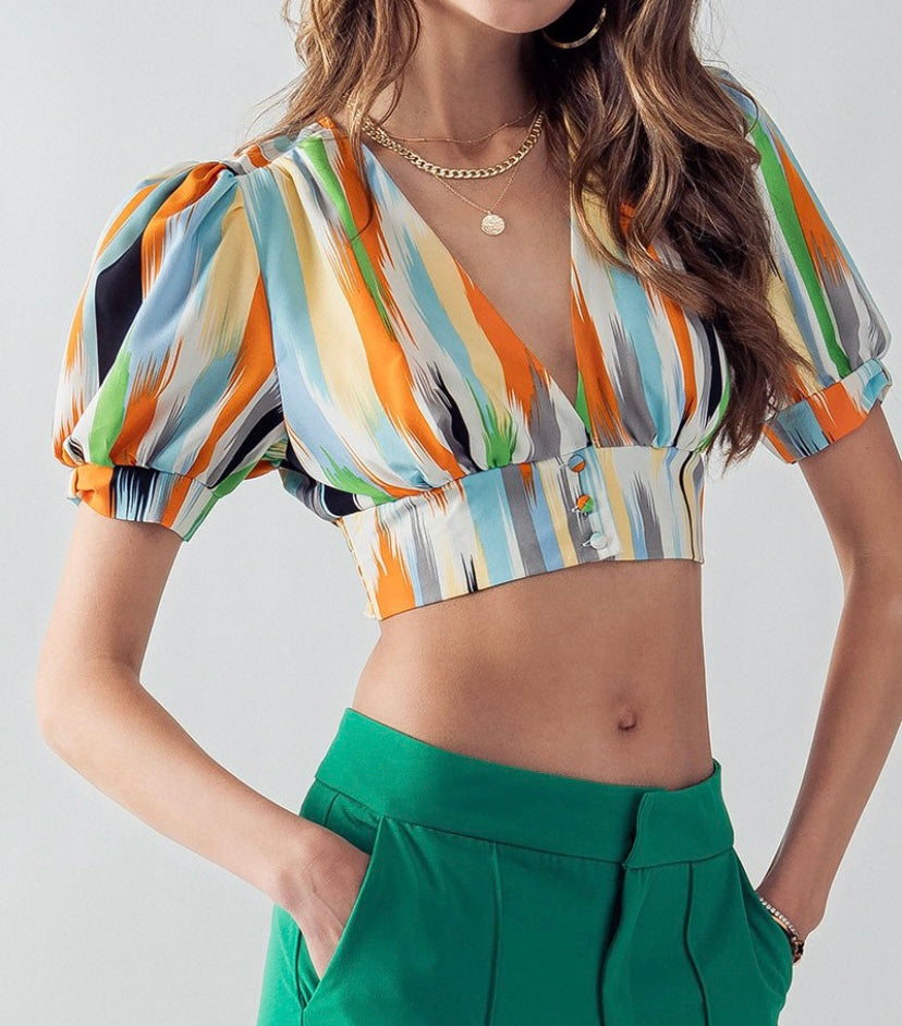 Abstract print crop top blouse with streaks of orange, gray, blue, white, green, and yellow.