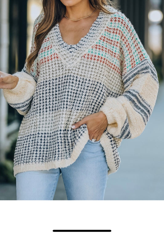 Oversized cream sweater with navy, gray, teal, and red stripes