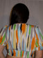 Abstract print crop top blouse with streaks of orange, gray, blue, white, green, and yellow.