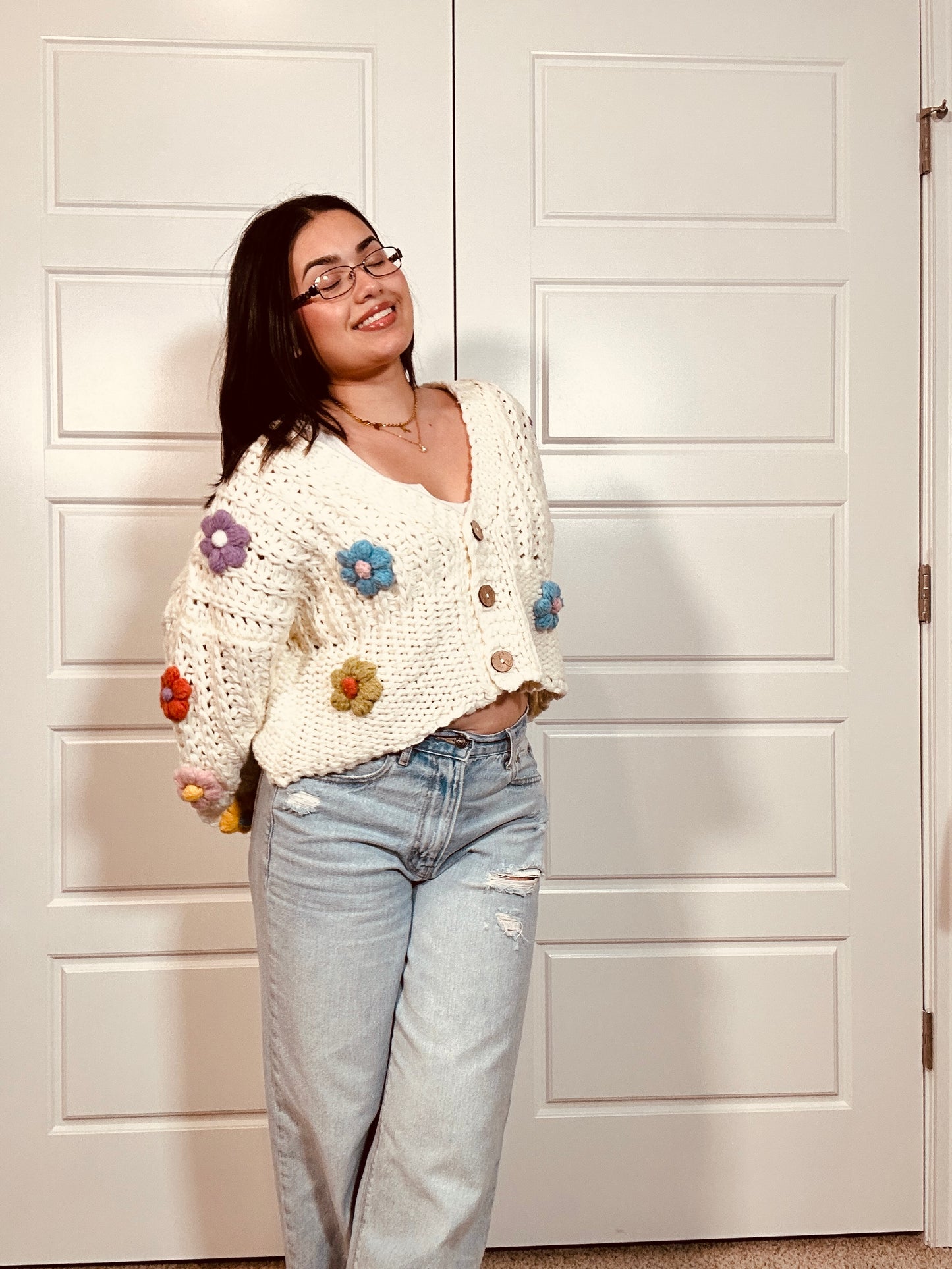 Crochet white cardigan sweater with brown buttons and multi colored crocheted flowers