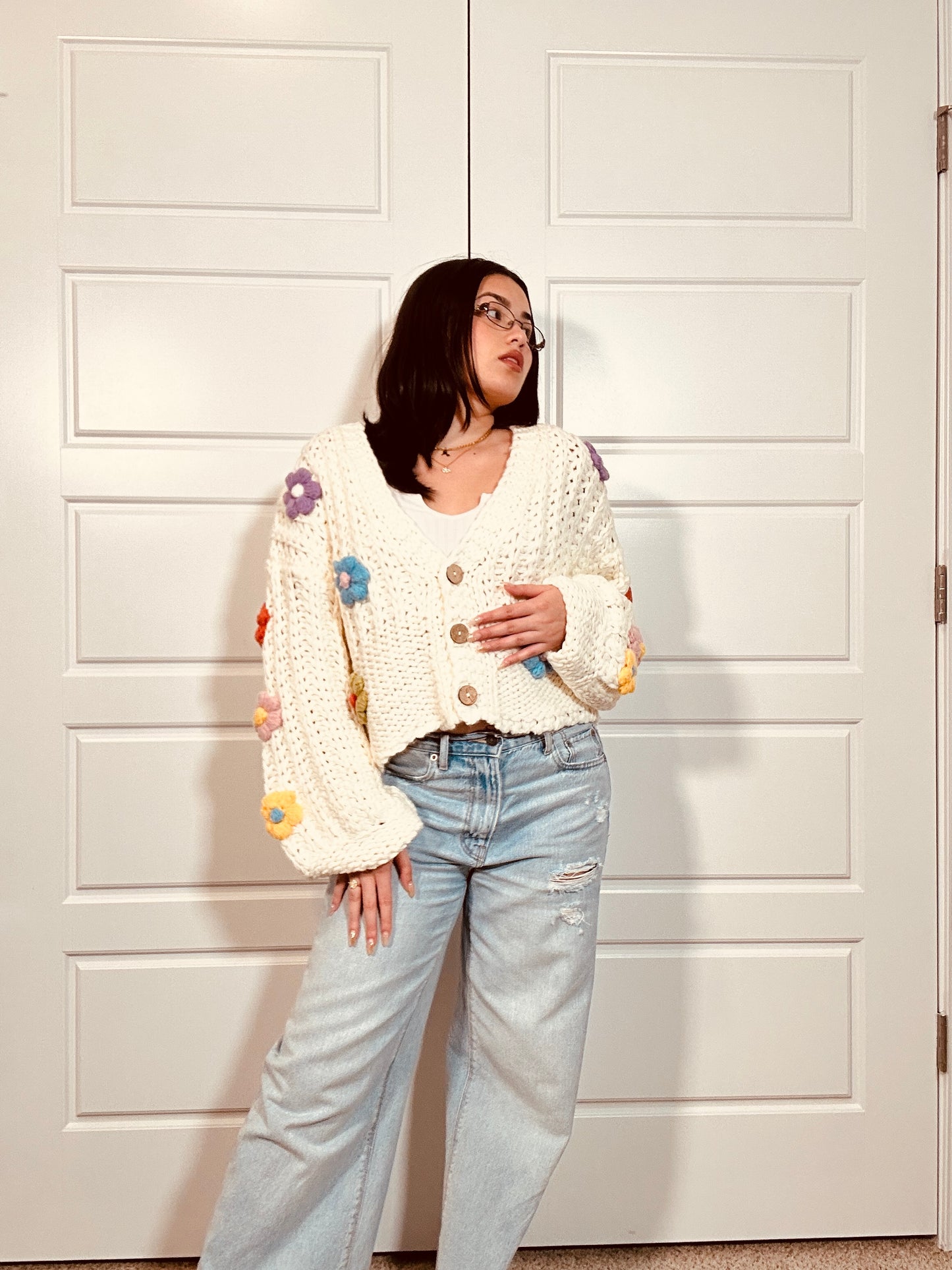 Crochet white cardigan sweater with brown buttons and multi colored crocheted flowers