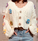 Crochet white cardigan sweater with brown buttons and multi colored crocheted flowers