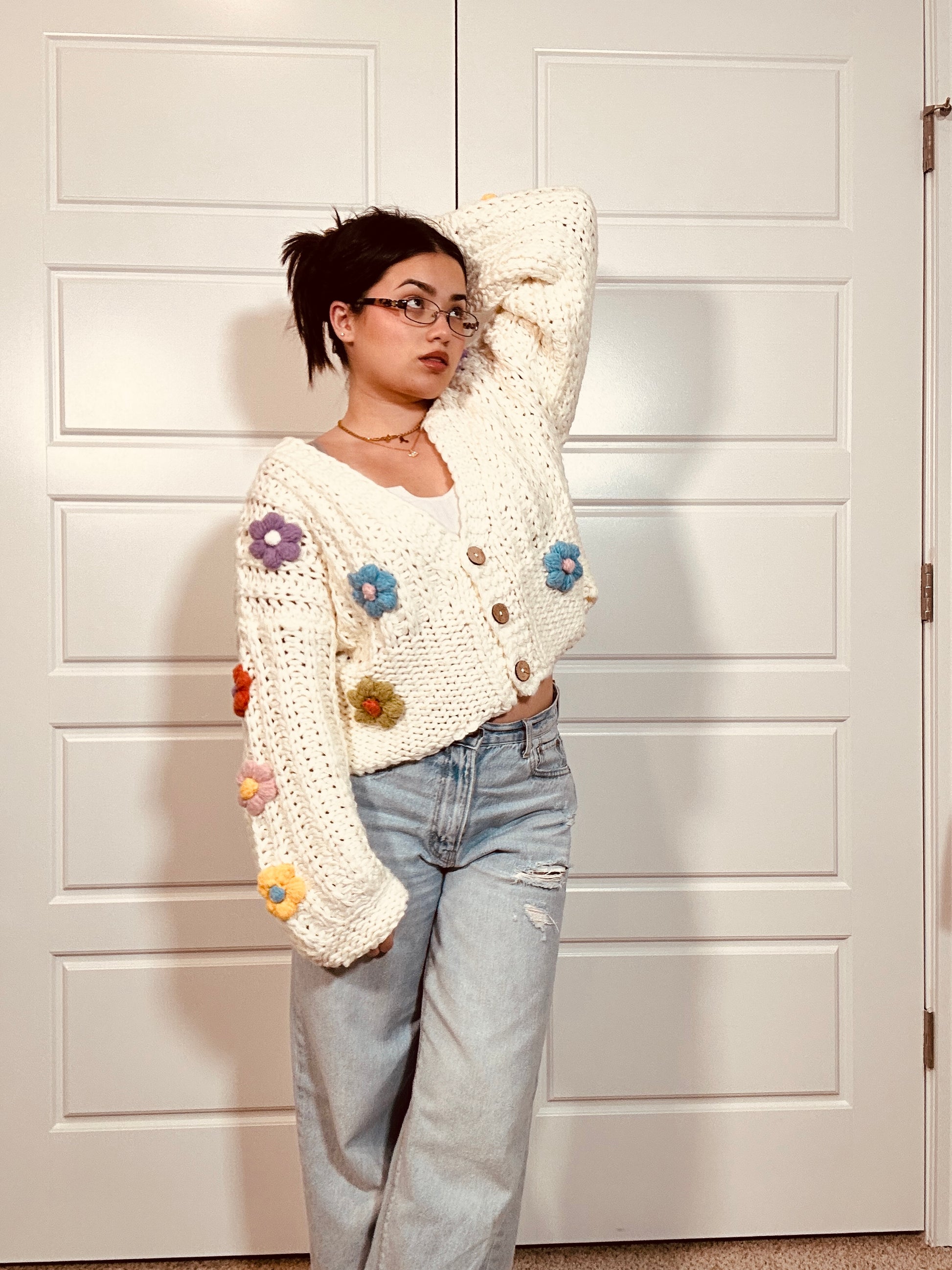 Crochet white cardigan sweater with brown buttons and multi colored crocheted flowers