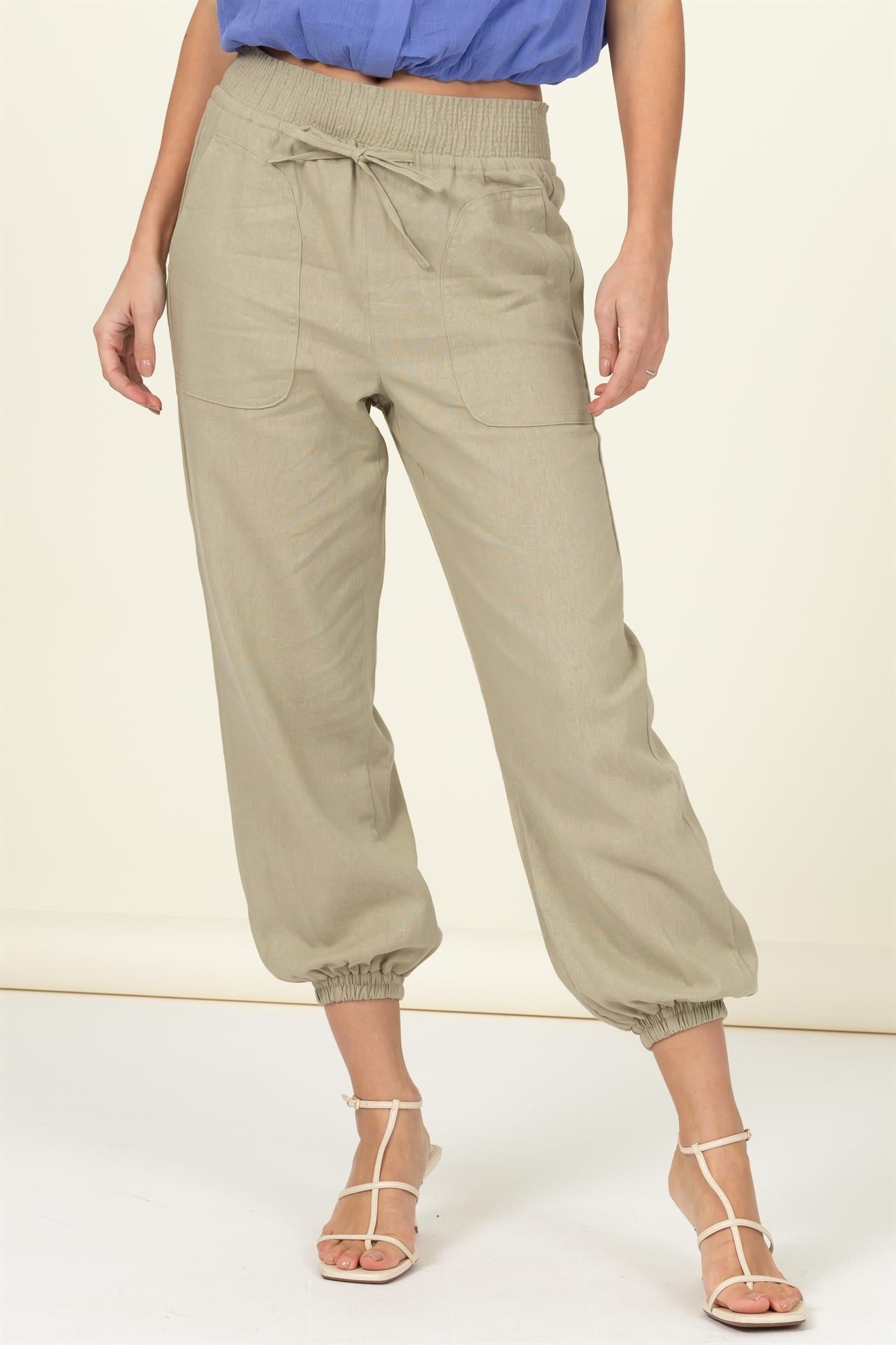 High waisted tan linen blend pants with elastic ankle, drawstring waist, and large pockets