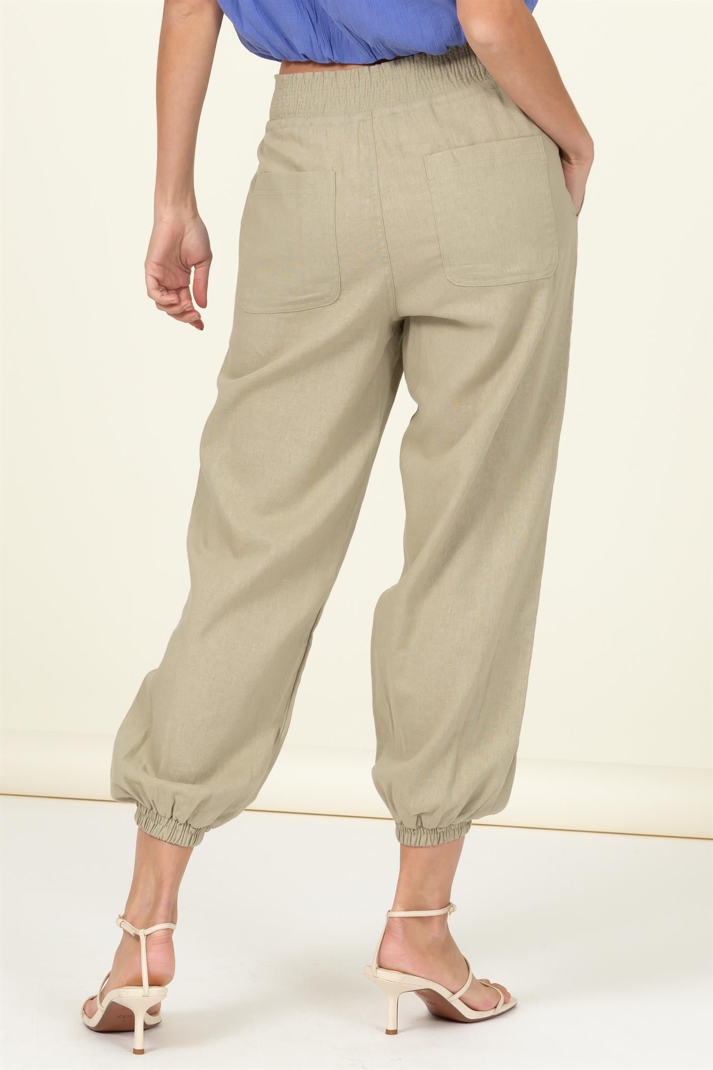 High waisted tan linen blend pants with elastic ankle, drawstring waist, and large pockets